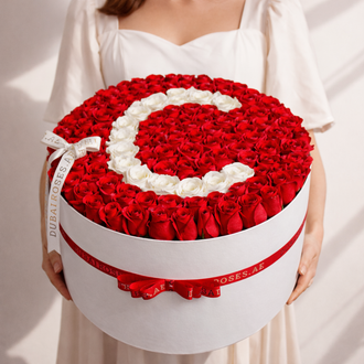 red roses in round box with letter