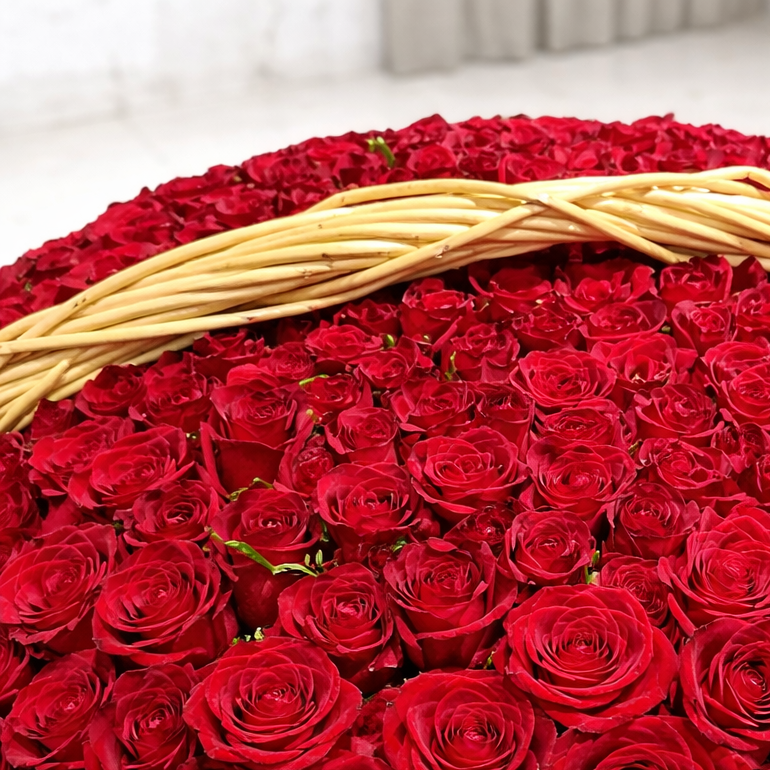 An exceptionally large, dome-shaped arrangement of 1000 fresh red roses in a grand wicker basket.