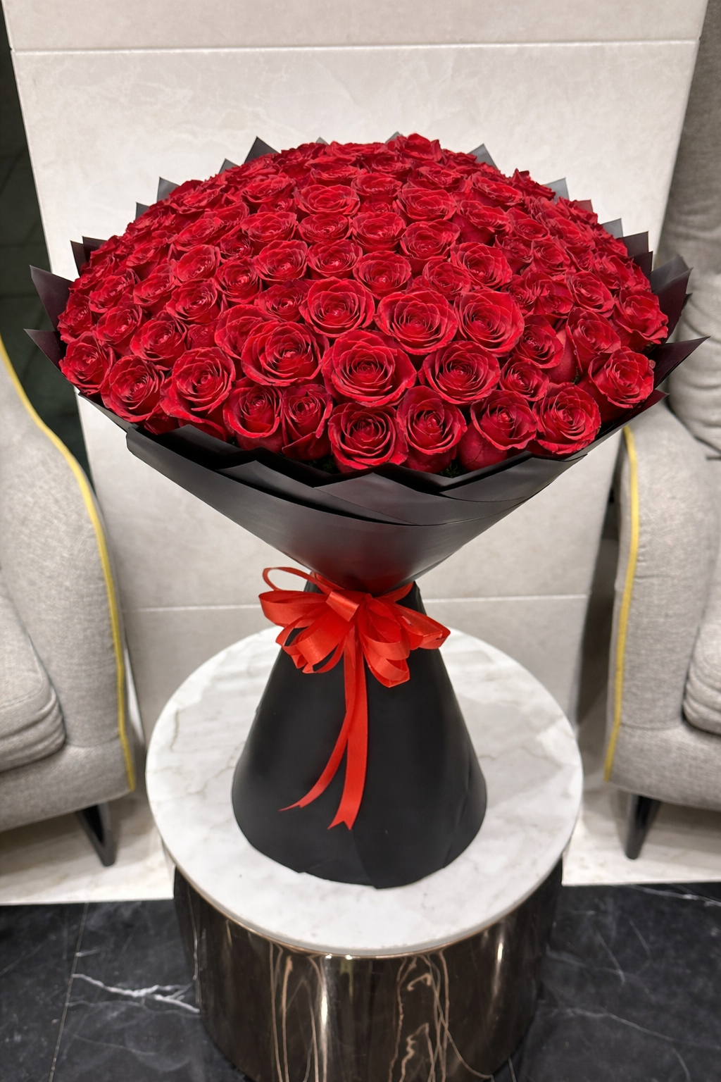 Luxury bouquet of fresh red roses with black wrapping and red ribbon, same-day flower delivery in Dubai