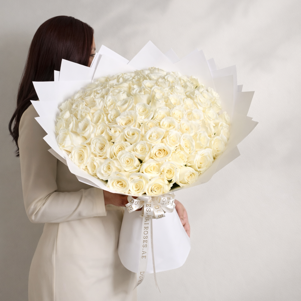 100 white roses bouquet with a lady holding it