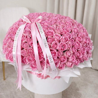 A close-up of a premium large-scale floral box featuring 200 dense, fresh pink roses in a professional designer black hatbox.