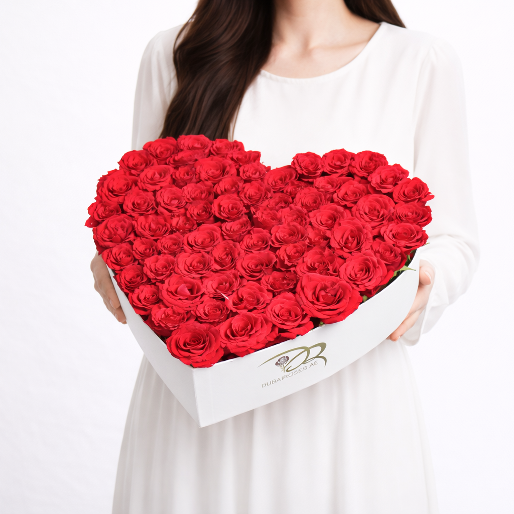 A lady holding a heart-shaped box of red roses on a white background