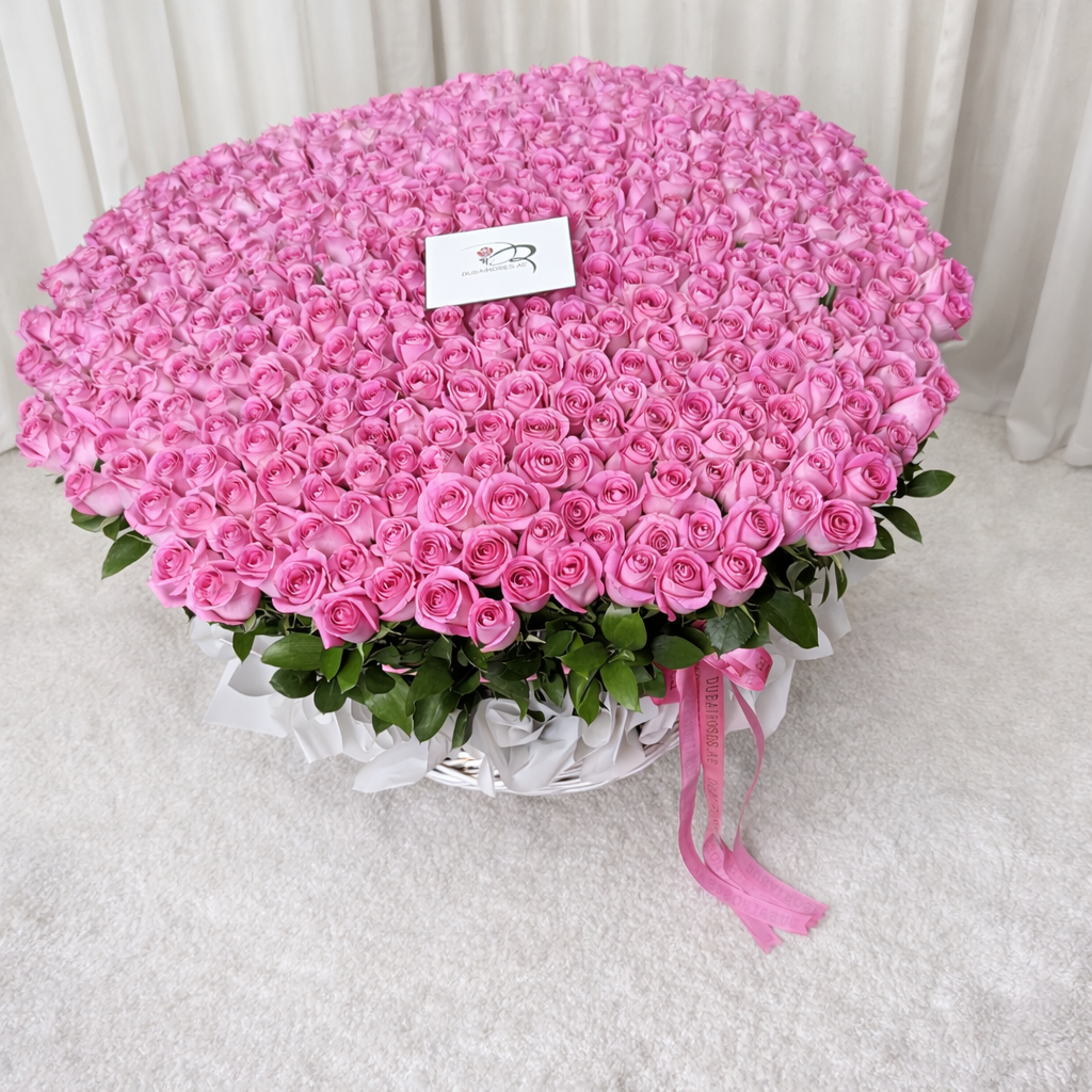 a top view of 500 pink roses in basket against a neutral background