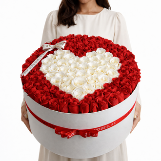 a woman holding a white round box of red roses with heart shape of white roses in middle of the arrangement.
