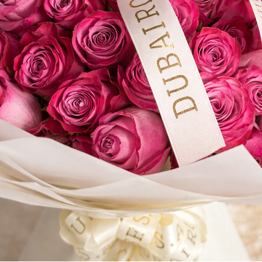 a close up photo of deep purple roses bouquet