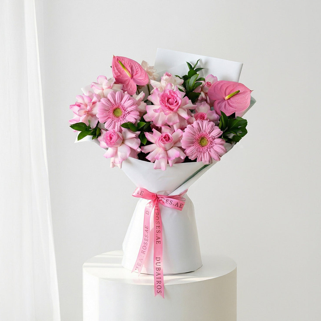 Woman holding a bouquet of pink flowers with a white background