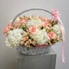 A basket full of flowers with a pink ribbon